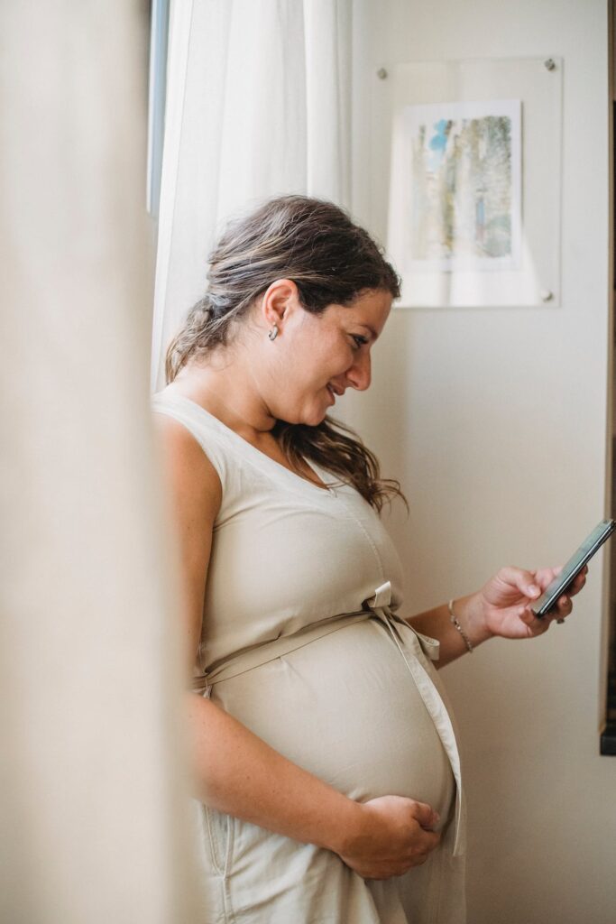 kobieta przegląda na smartfonie aplikacje ciążowe