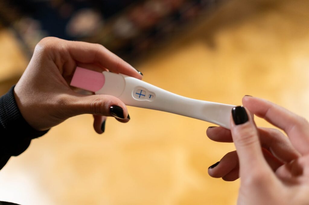 pierwszy trymestr ciąży: kobieta trzyma w dłoniach pozytywny test ciążowy