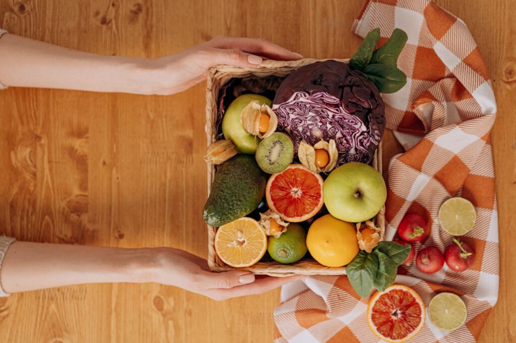 Dieta przed ciążą - kobieta z pojemnikiem z owocami w dłoniach