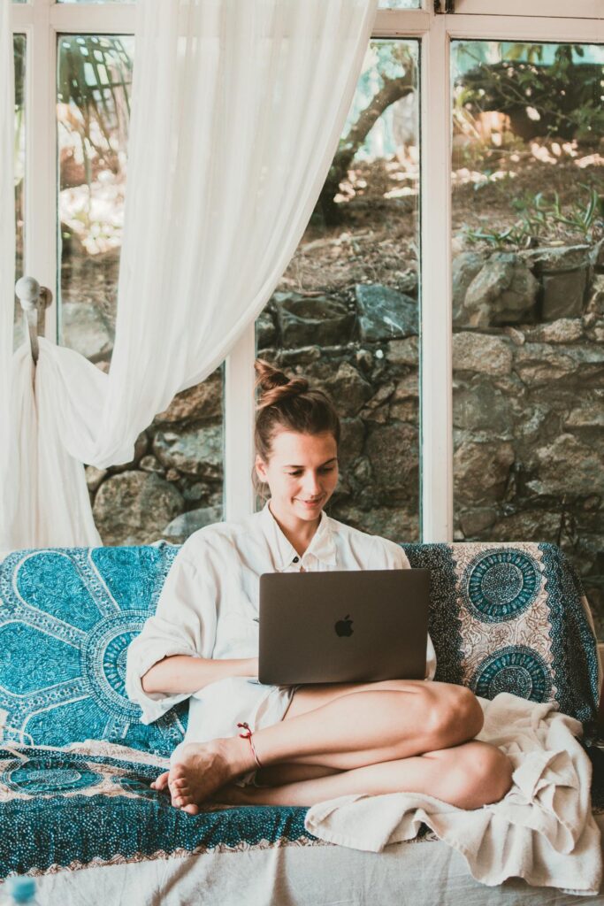 praca online dla mam: kobieta siedzi na kanapie z laptopem